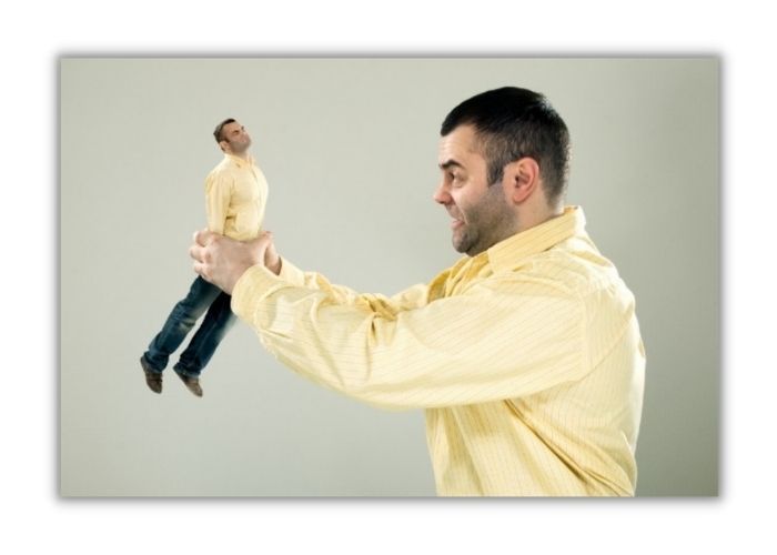 man shaking the life of of miniature version of himself